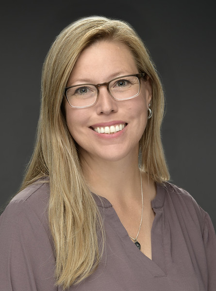 Amanda Stratford, wedding photographer, in a grey studio portrait